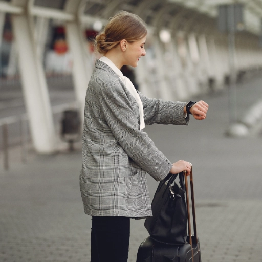 Voyageuse vérifiant l'heure sur le quai d'une gare avant la prise en charge par son taxi réservé depuis Marignane