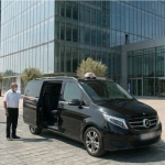 Chauffeur de taxi conventionné ouvrant la portière d'une Mercedes Classe V pour un transfert radiothérapie vers Paoli-Calmettes