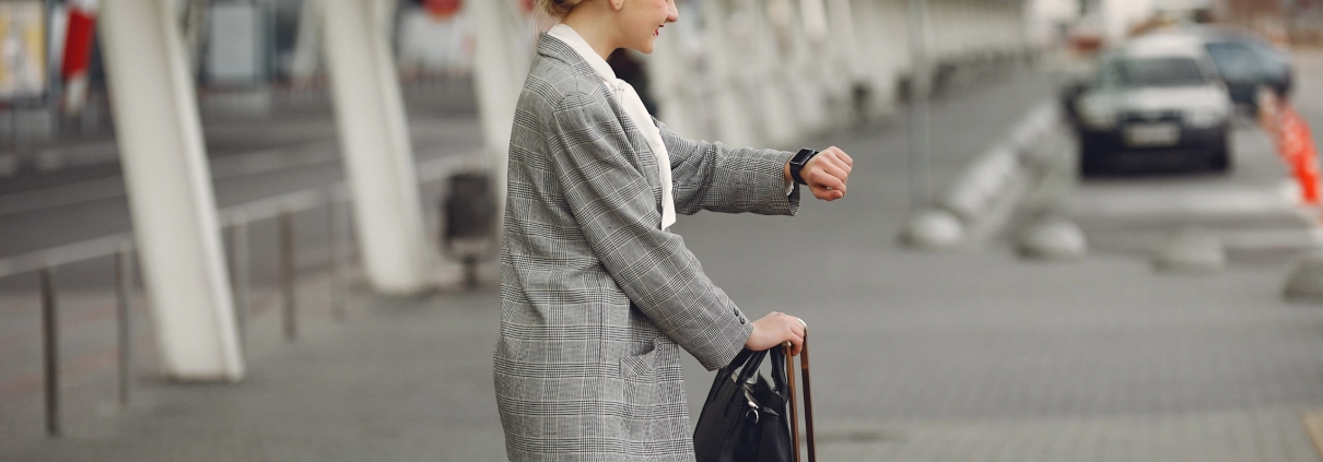 Voyageuse consultant sa montre en attendant son taxi réservé en ligne, confirmation rapide avec réponse directe du chauffeur en Provence